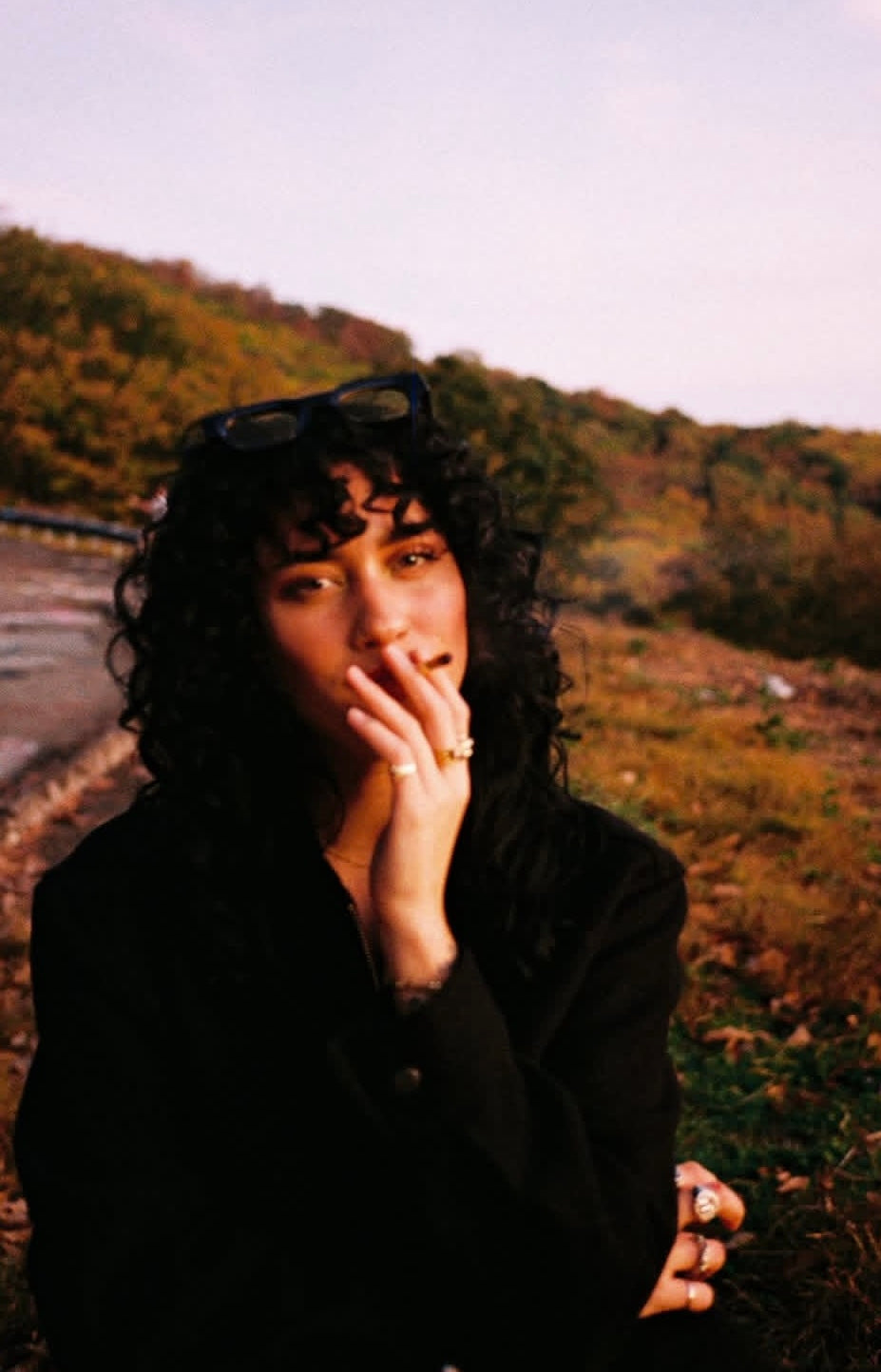 Woman enjoying a flower pre-roll outdoors in autumn scenery